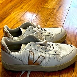 Veja white leather sneakers with canvas/knot insets and gold detailing.